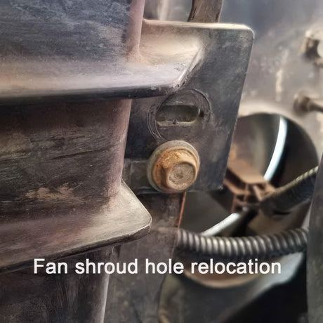 A photo of a fan shroud hole relocation with overlaying text that reads, fan shroud hole relocation in white text. 